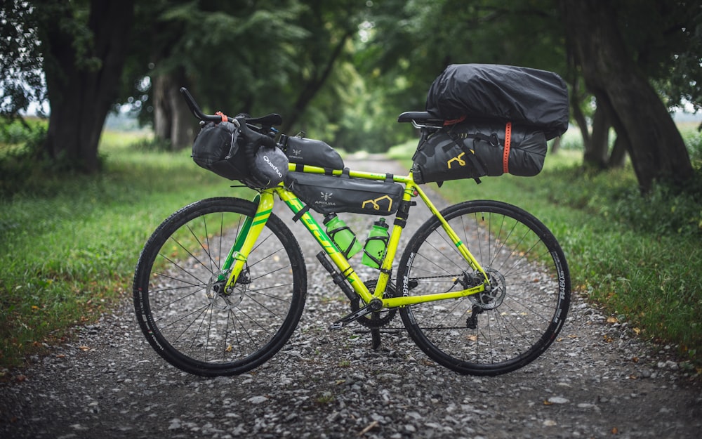 mountain bike verde e preta na estrada de terra
