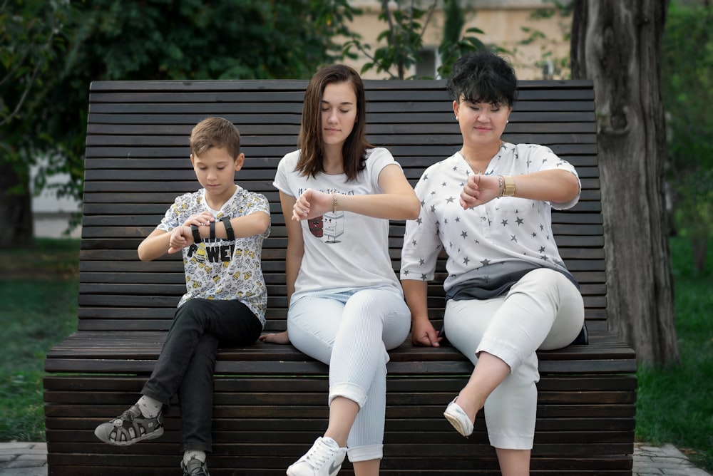 man and woman sitting on brown wooden bench