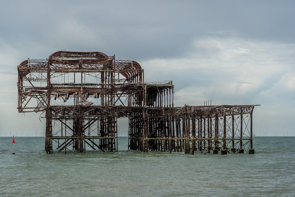 a rusted structure sitting in the middle of the ocean