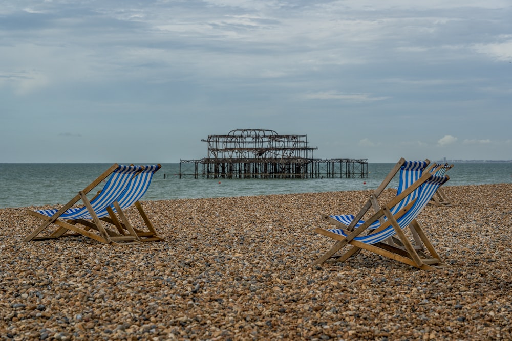 日中のビーチにある茶色の木製の折りたたみ椅子
