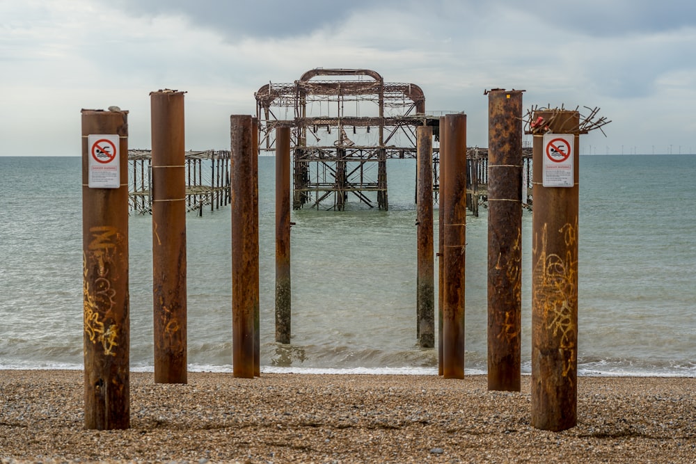Poteaux en bois brun sur la plage pendant la journée