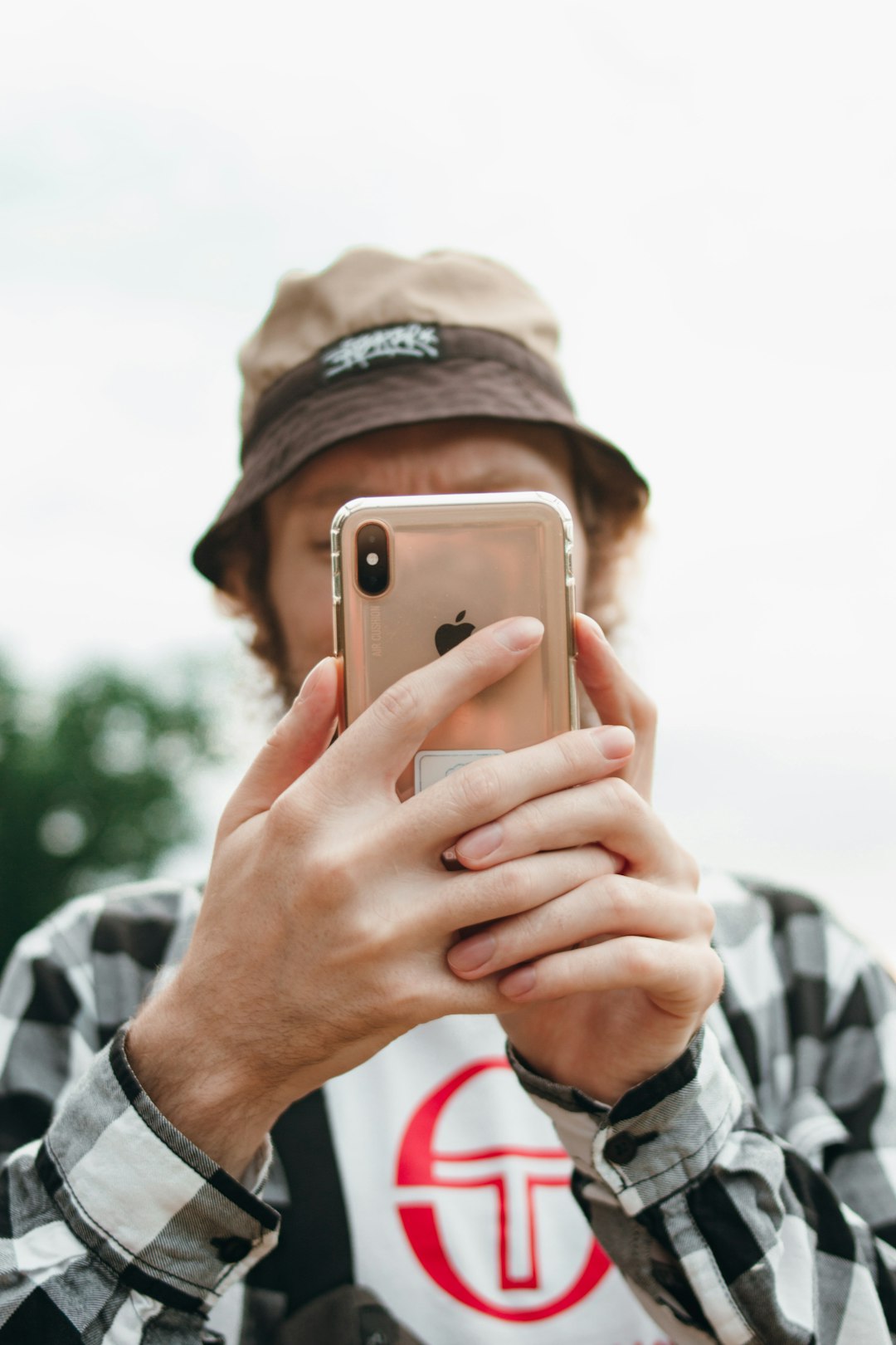 man in black knit cap holding silver iphone 6