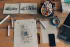 Architectural blueprints and engineering tools on a desk beside decorative samples