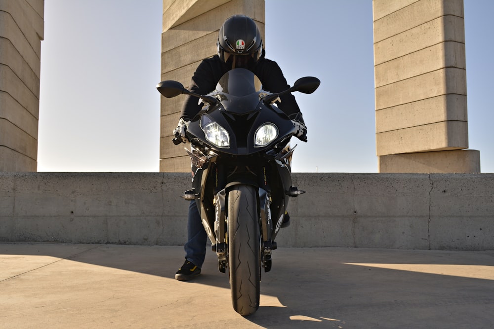 黒いバイクに乗る黒いヘルメットの男