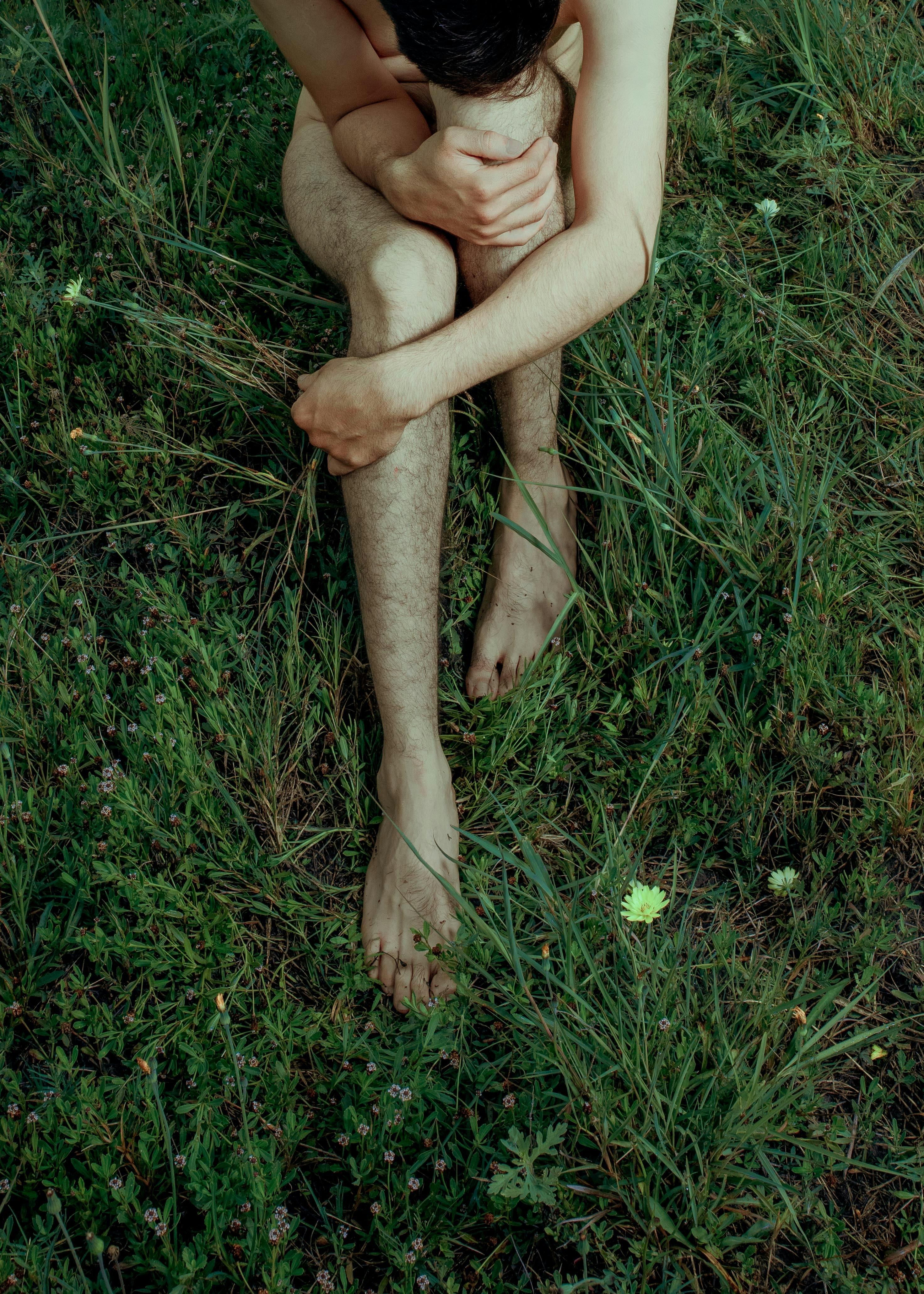 person sitting on green grass field during daytime