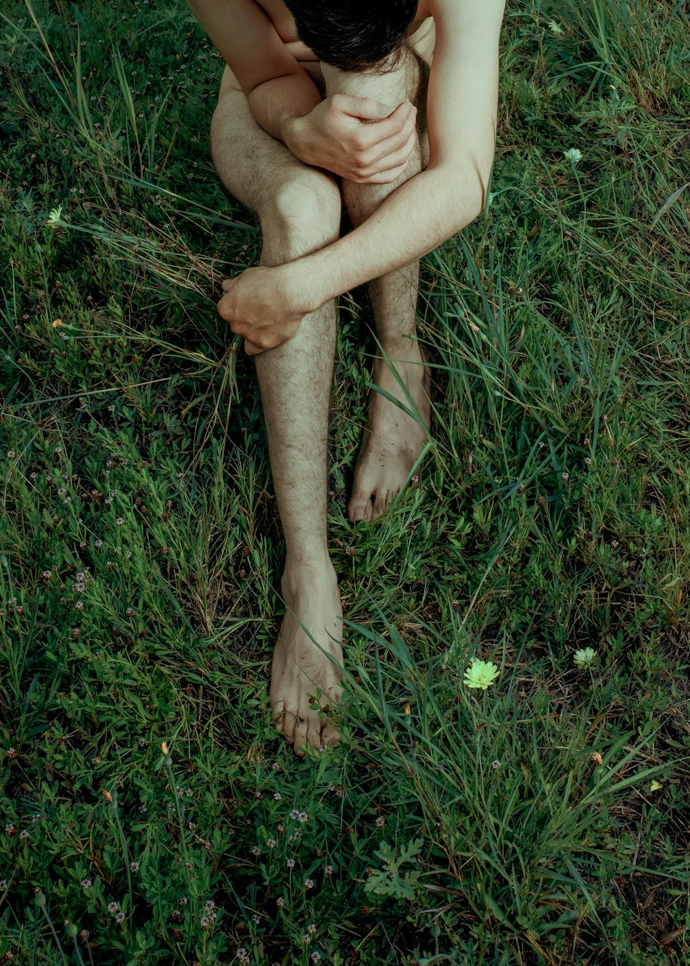 pessoa sentada no campo de grama verde durante o dia