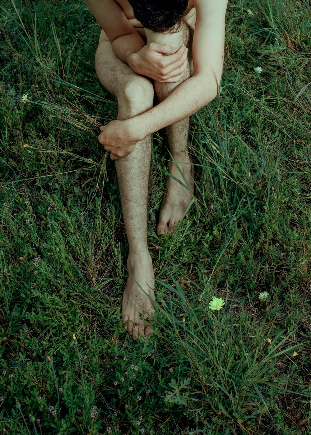 person sitting on green grass field during daytime