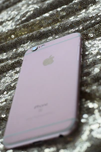 A sleek smartphone displaying vibrant social media posts with gold accents.