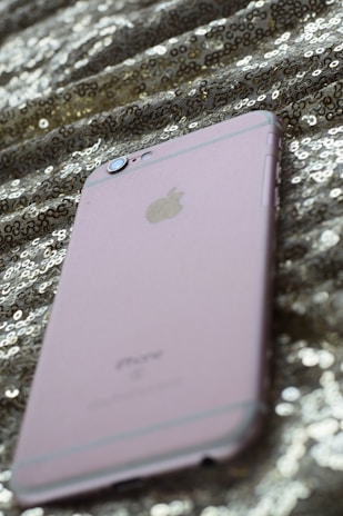 Close-up of a rose gold-accented phone case resting on a sleek black fabric background.