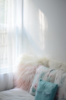 A sunlit room showcasing elegant curtains and cozy cushions from Gangaur Textiles.