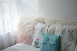 Comfortable seating area inside the room with pillows in soft turquoise and white tones.