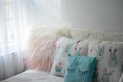 Comfortable seating area inside the room with pillows in soft turquoise and white tones.