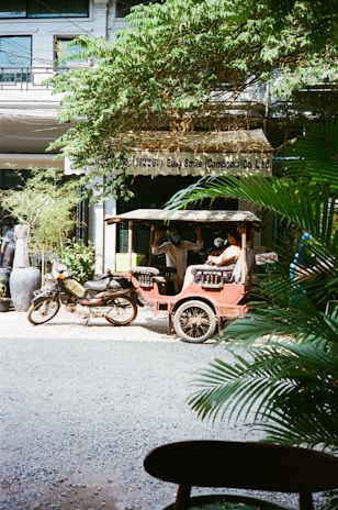 Close-up of a khahoma branded bike taxi parked outside a busy office building.