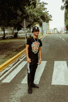 A casual street scene featuring a man wearing a graphic black t-shirt.