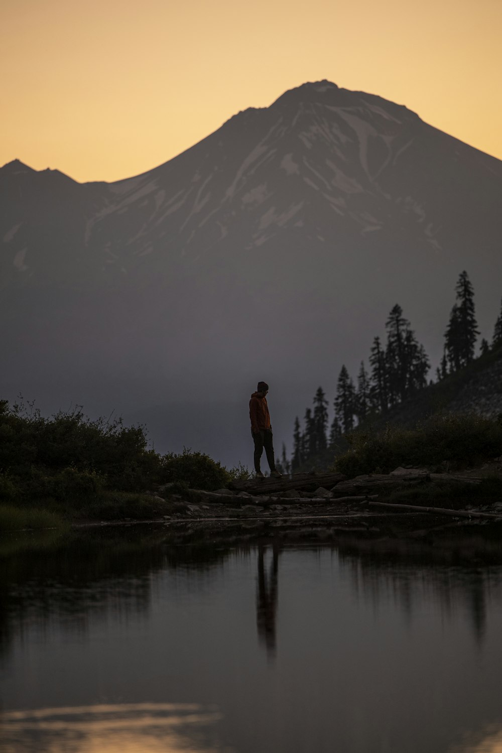 man standing on rock near lake during daytime