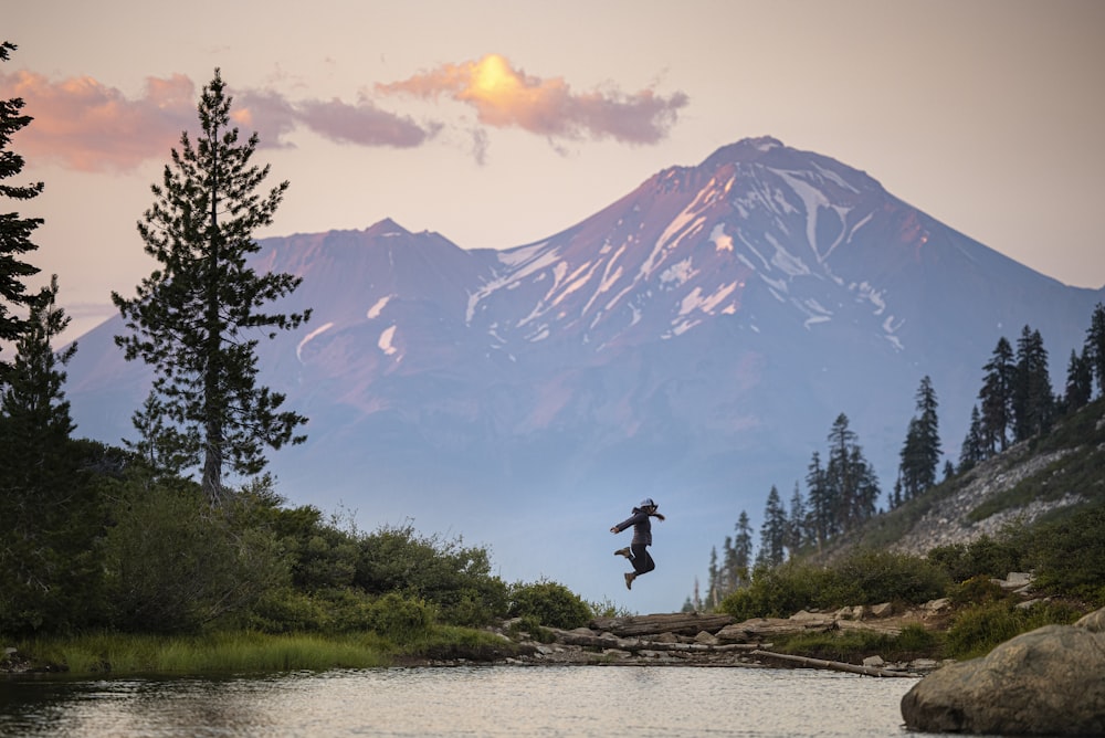 person standing on rock near body of water during daytime