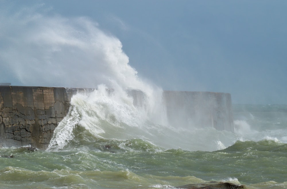 water falls under blue sky during daytime