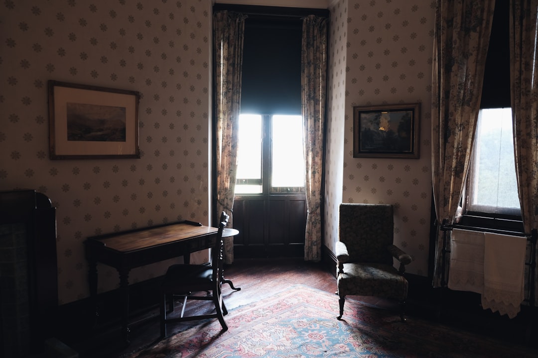 brown wooden armchair near brown window curtain