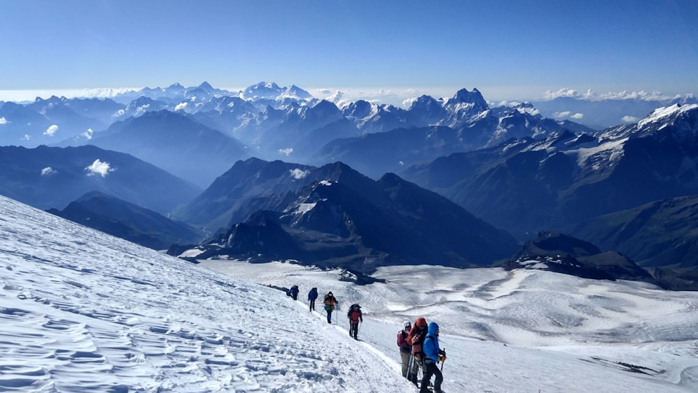 people hiking on snow covered mountain during daytime