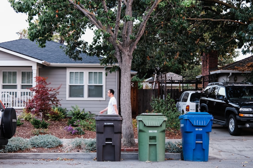 woman in white shirt standing near green tree during daytime