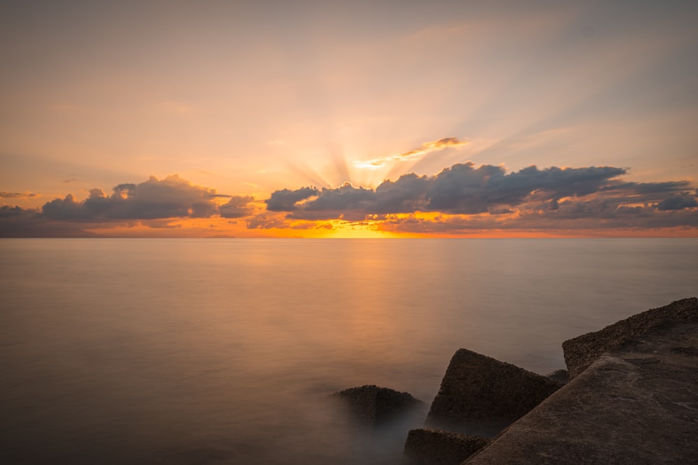 body of water under cloudy sky during daytime