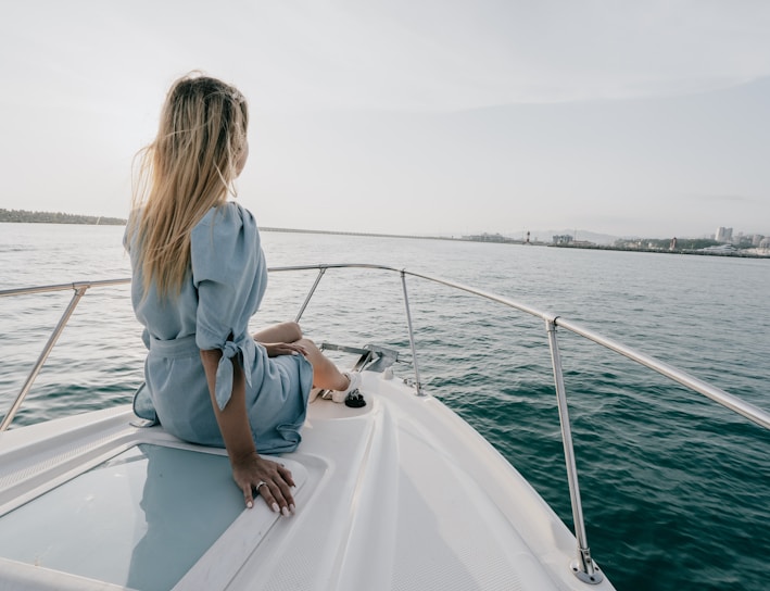 woman in white long sleeve shirt sitting on white boat during daytime