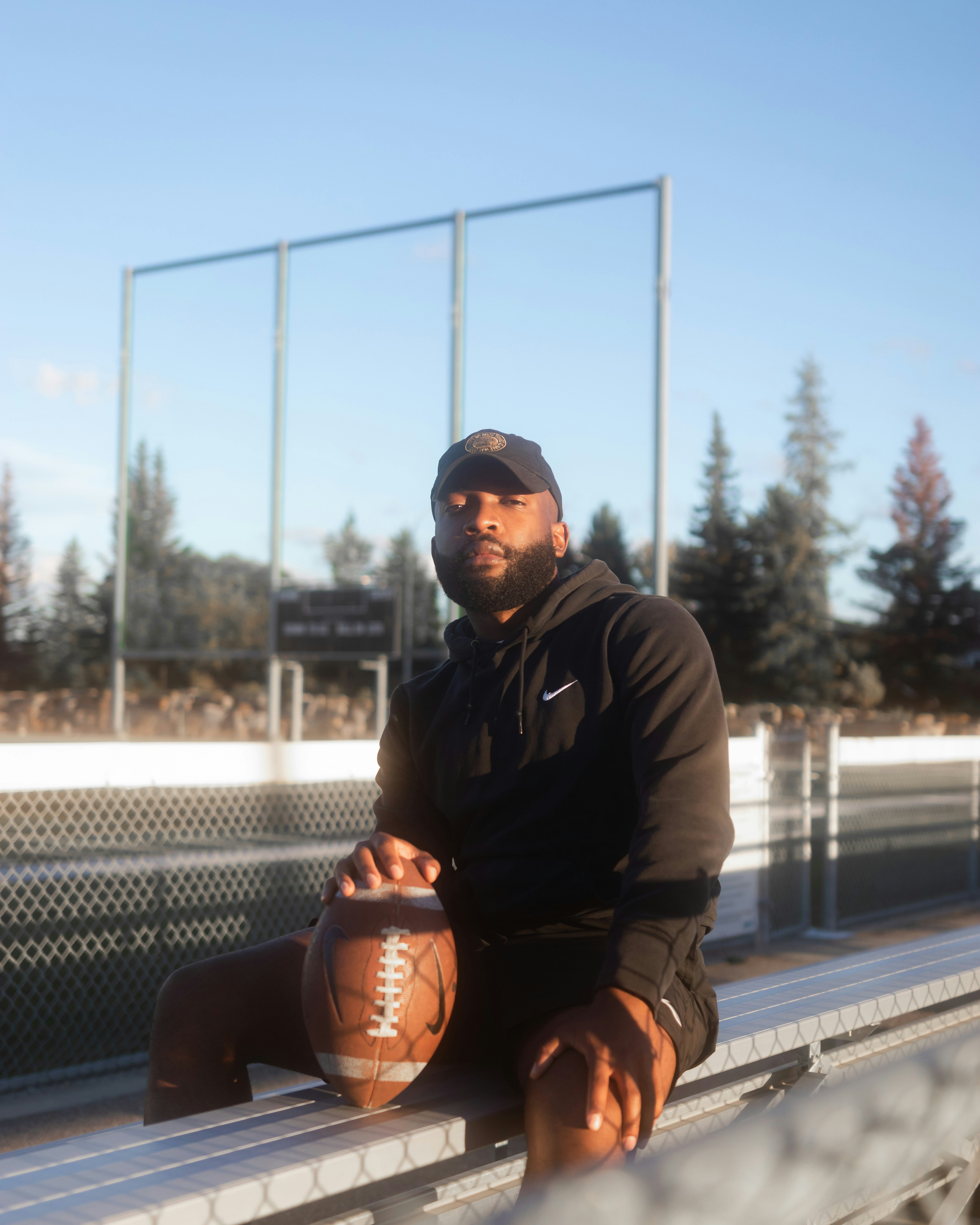 man in black jacket and black pants sitting on black bench during