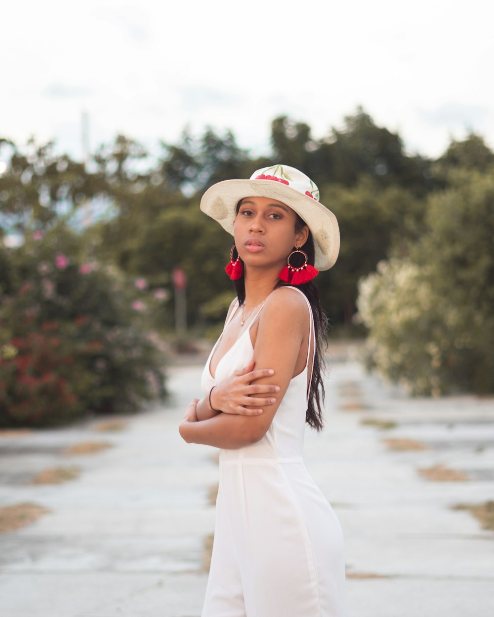 woman in white tank top and white hat standing on beach during daytime