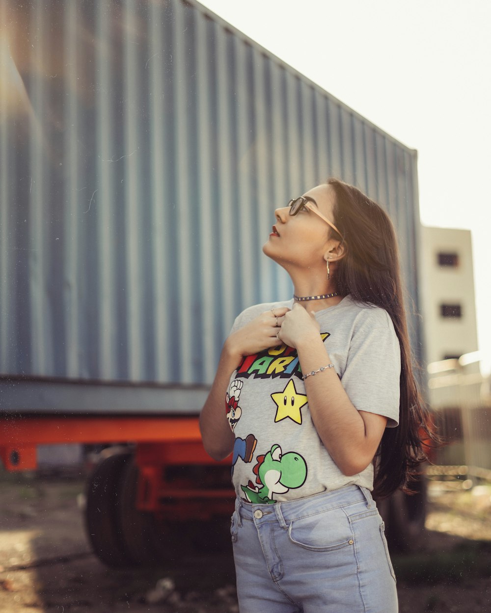 woman in gray t-shirt standing near red car during daytime