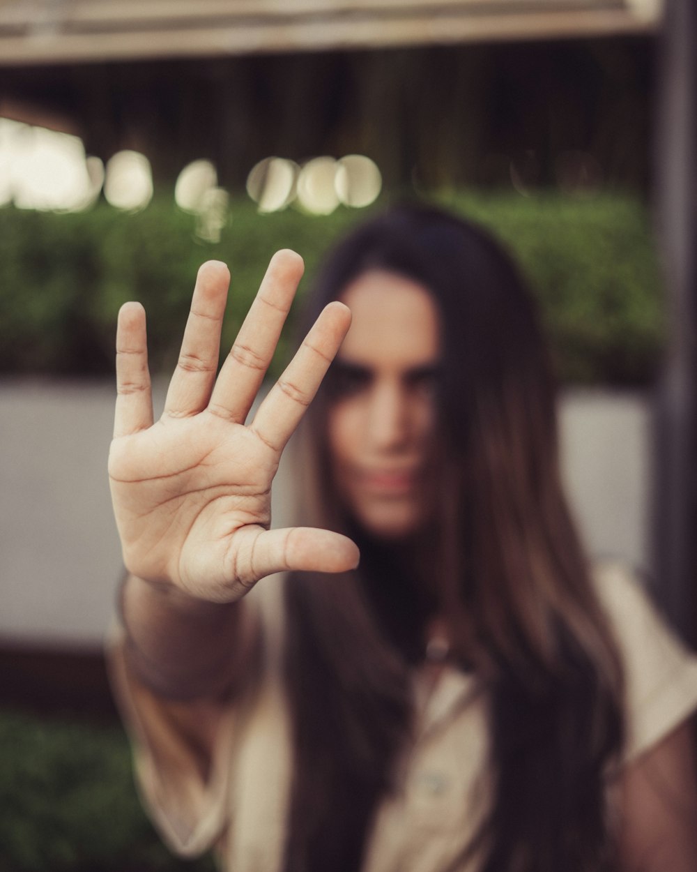 woman in black shirt covering her face with her hands