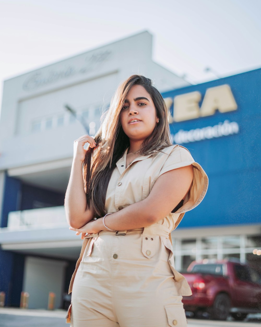 woman in beige sleeveless dress standing near blue and white building during daytime