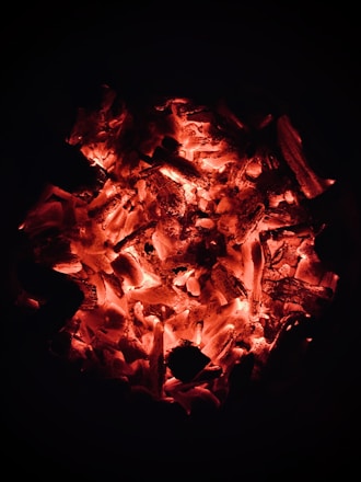 A captivating image of a gathering with glowing embers and a dark, dramatic background.