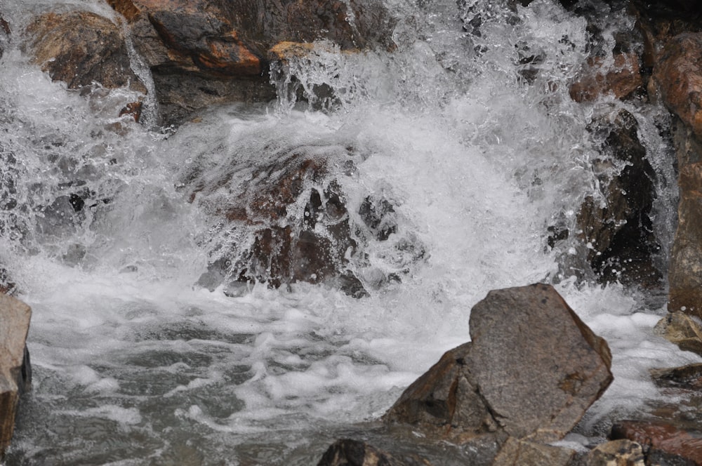 water waves hitting brown rocks