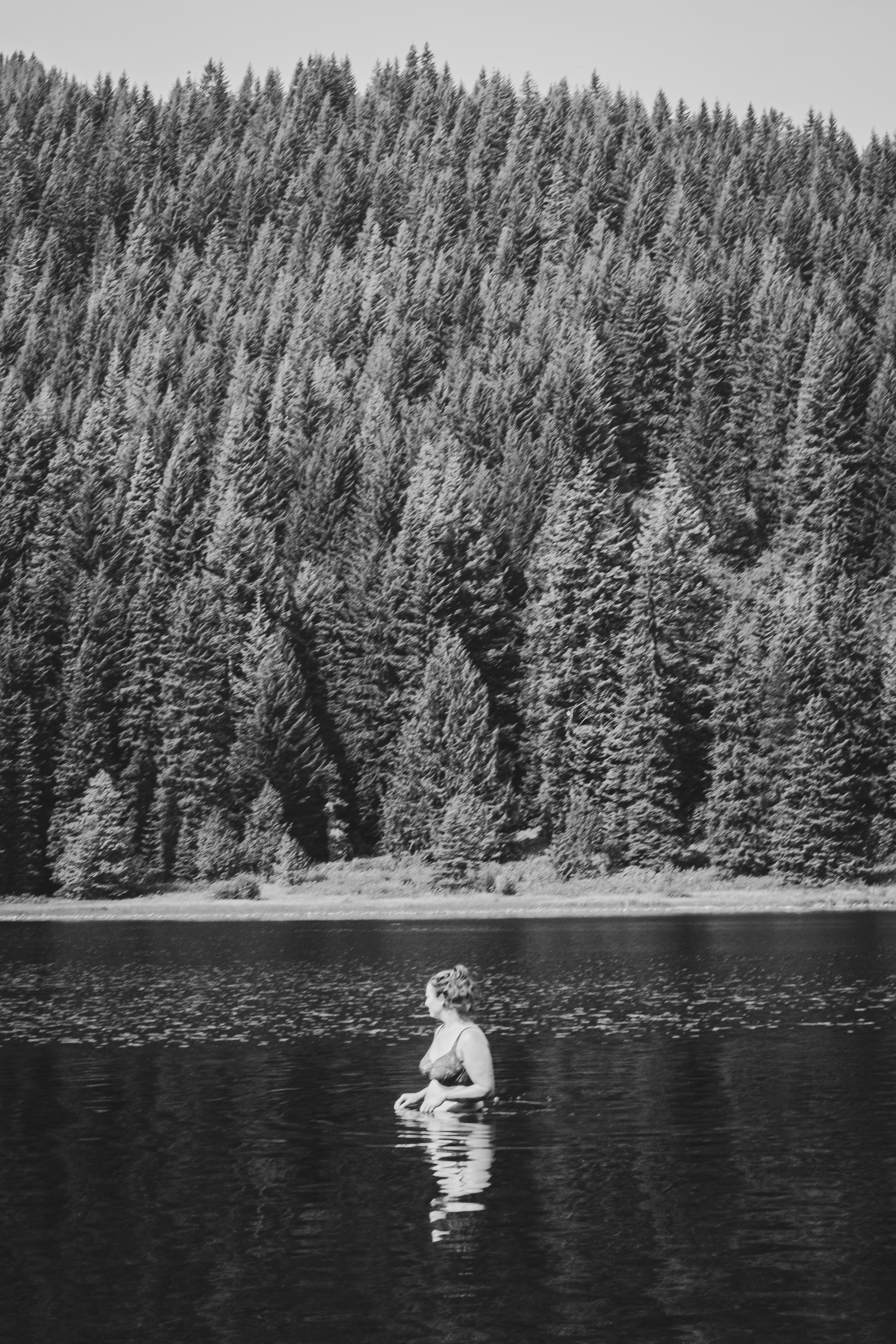 woman in white long sleeve shirt standing near lake