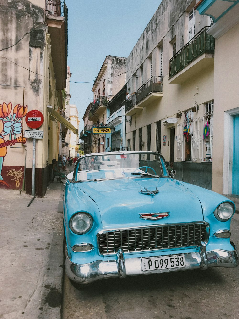 blue car parked beside building during daytime