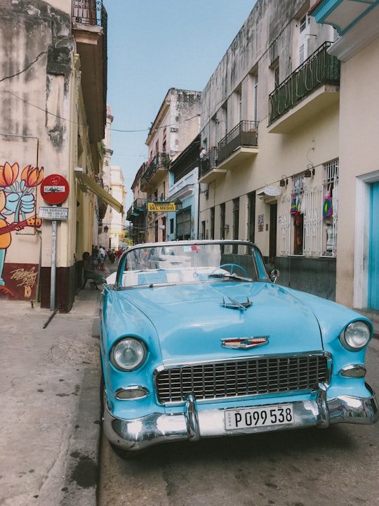 blue car parked beside building during daytime in La Bodeguita Del Medio Cuba