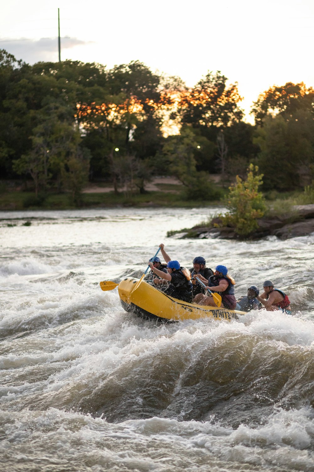 Eine Gruppe von Menschen fährt mit einem Floß einen Fluss hinunter