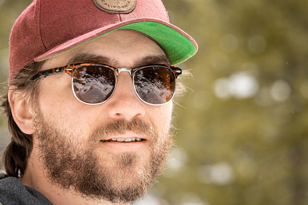 man in black sunglasses and brown hat