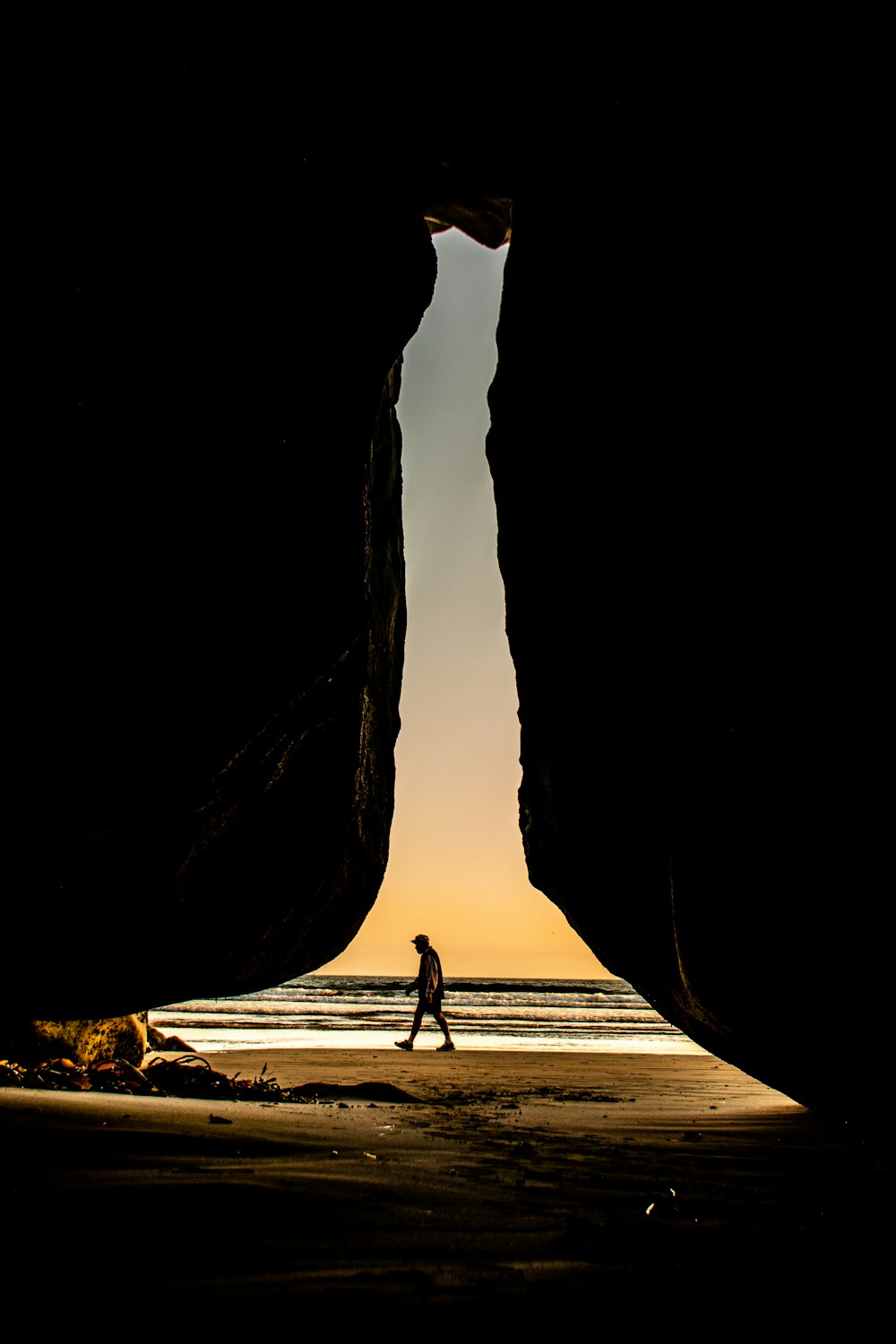 silhouette of man walking on beach during daytime