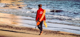 A lifeguard with walkie talkie, wearing a wetsuit and jacket, ready to respond to a water emergency