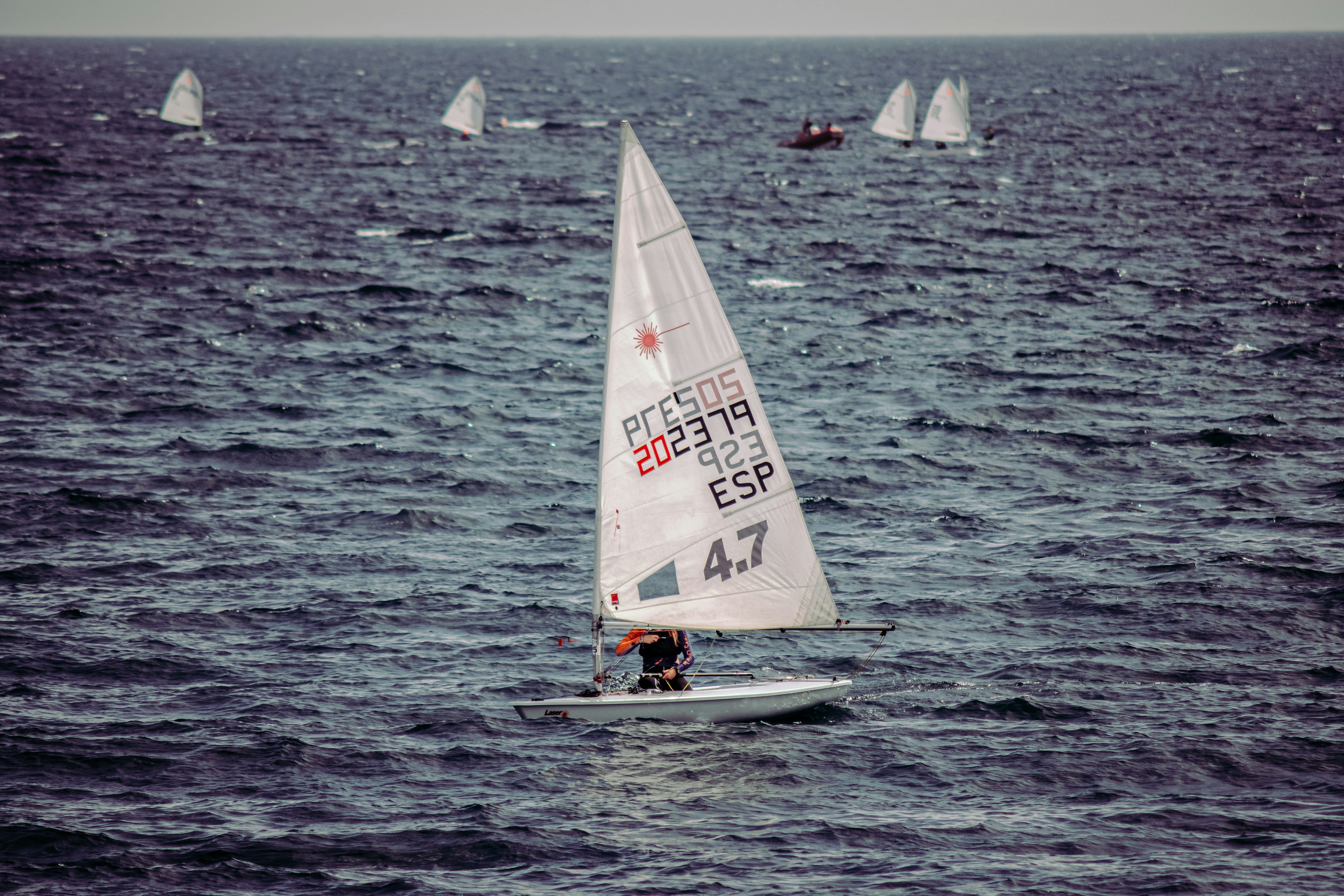 person in white sail boat on sea during daytime