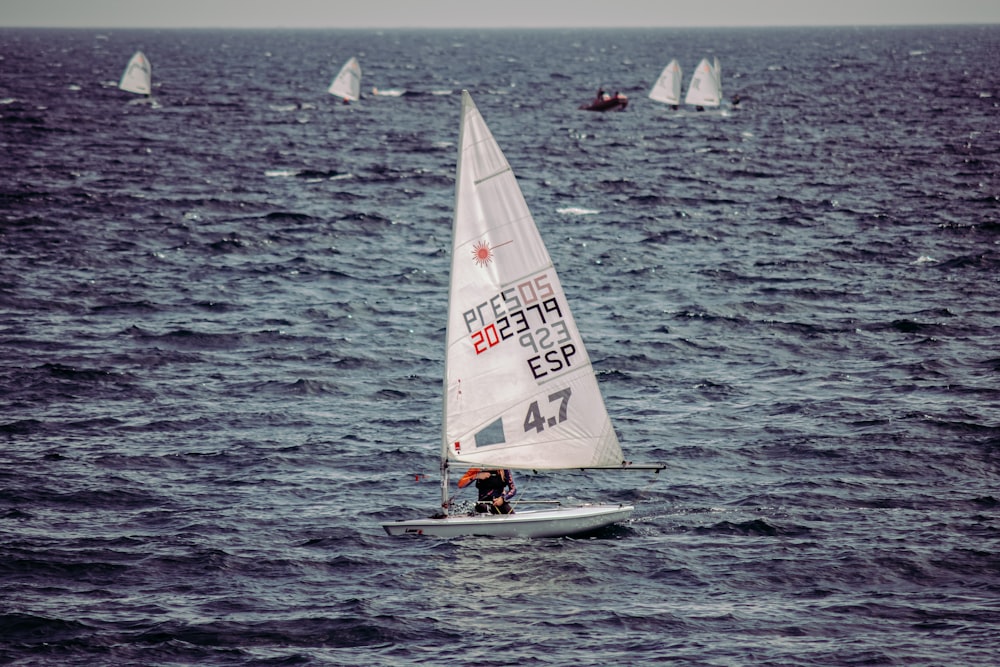 person in white sail boat on sea during daytime