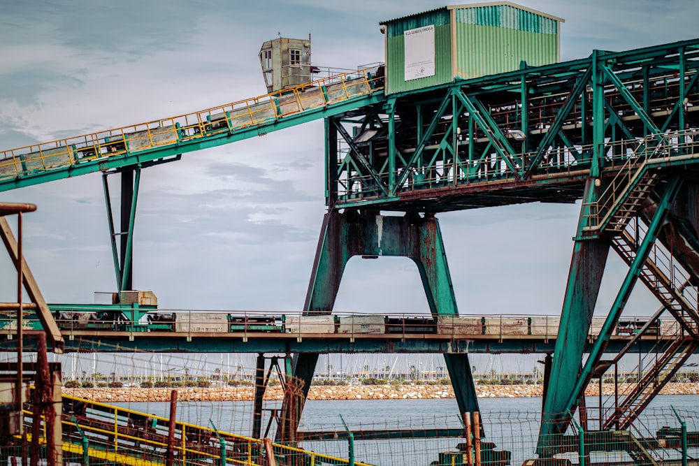 green and brown metal bridge under blue sky during daytime