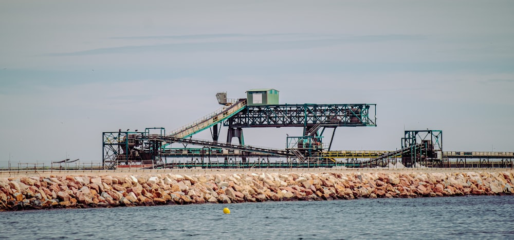 green and white metal bridge over the sea