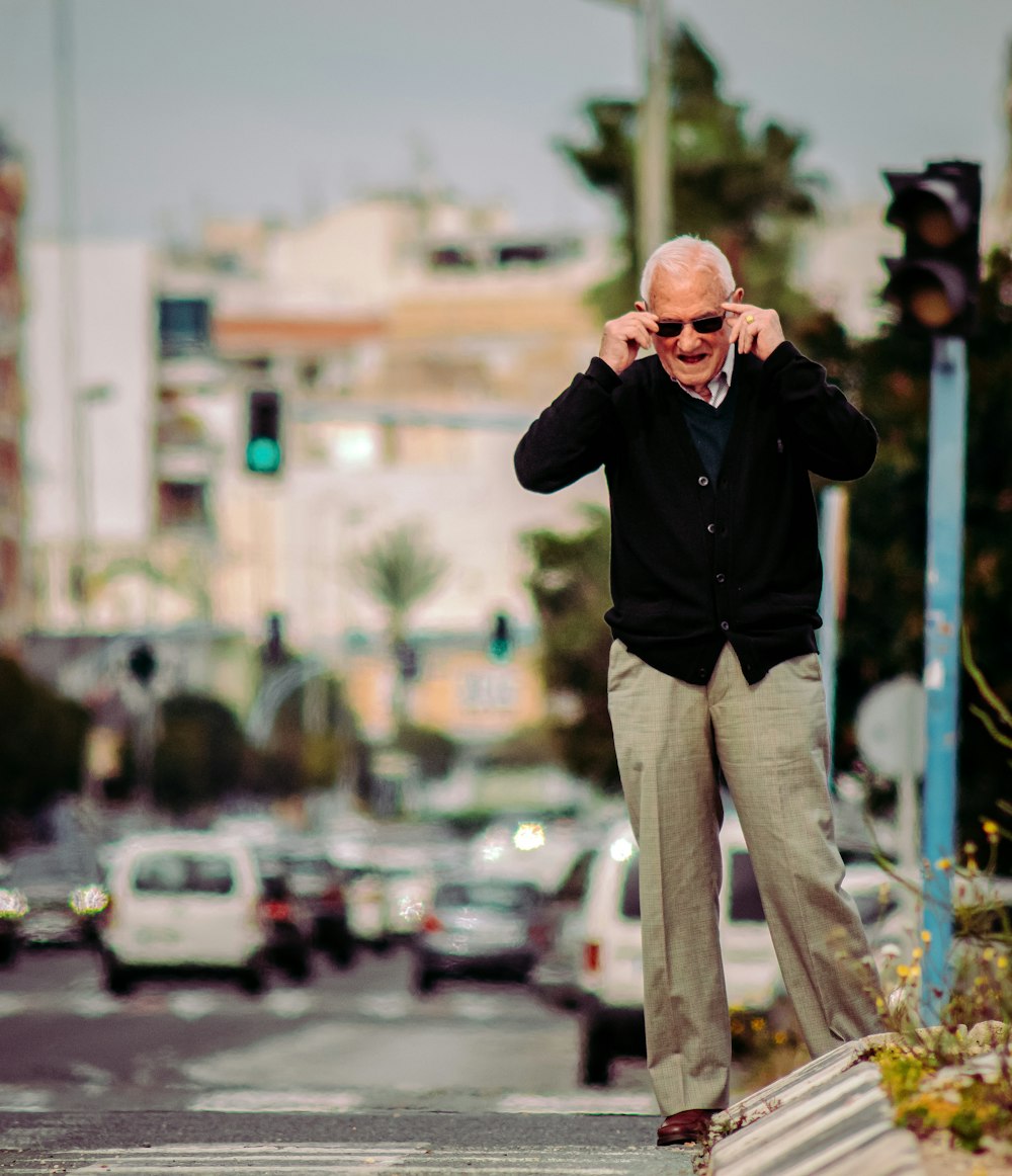 man in black jacket and gray pants standing on street during daytime