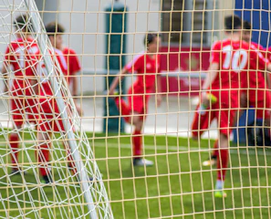 soccer players in red jersey shirt playing soccer during daytime