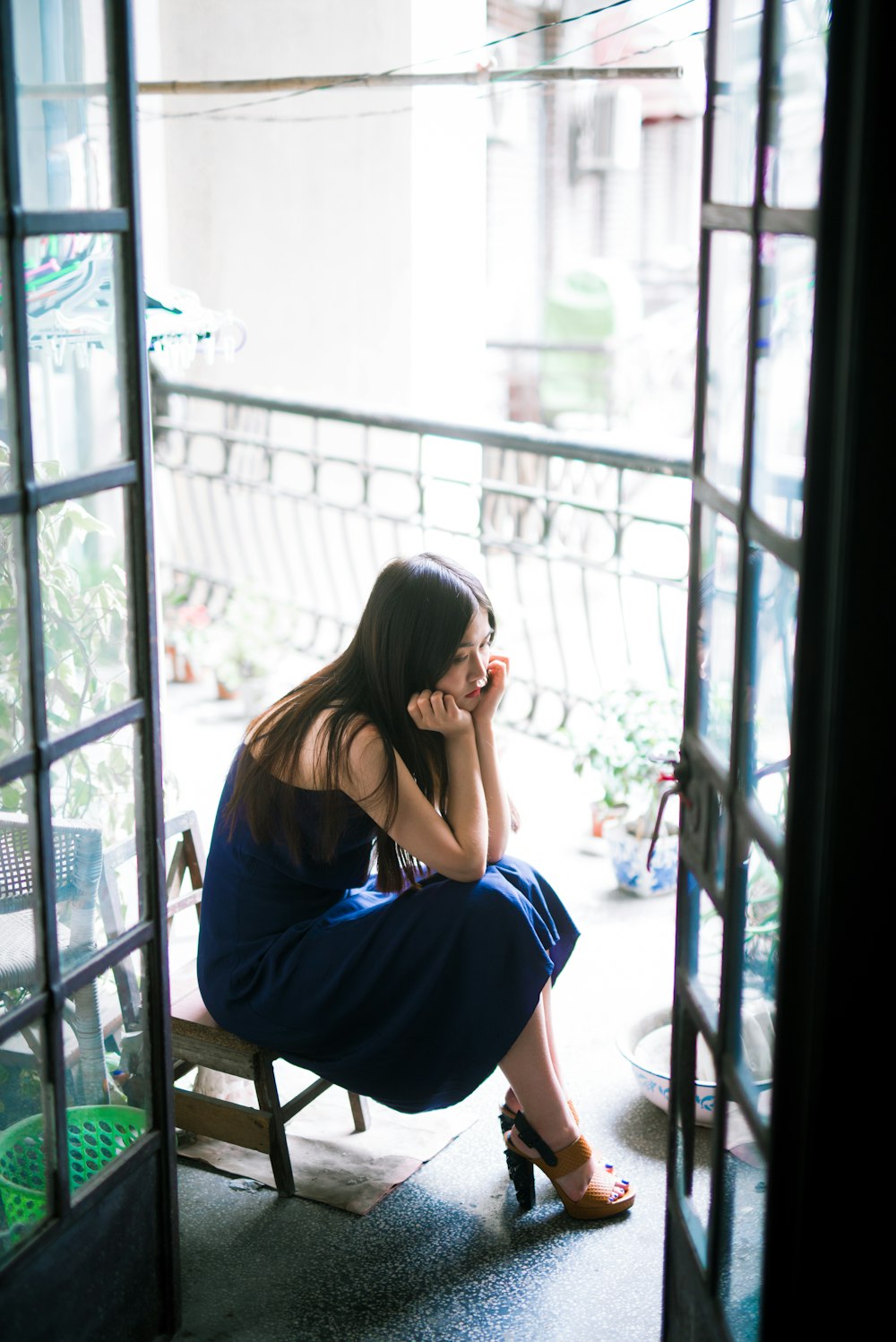 woman in blue dress sitting on brown wooden chair