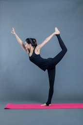 woman in black tank top and black pants raising her hands