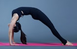 A fitness enthusiast stretching on a pink yoga mat.