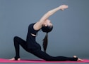 woman in black tank top and black pants doing yoga